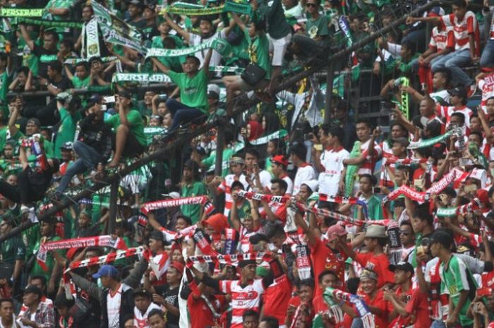Suporter Persebaya, Bonek dengan seragam hijau membaur bersama fan Madura United dengan warna kebesaran mereka, mereh pada laga pamungkas Grup C fase penyisihan Piala Presiden 2018 di Gelora Bung Karno, Kota Surabaya, Minggu (27/1/2018). 
