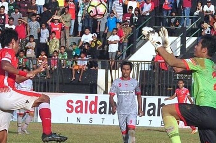 Kiper Martapura FC, Ali Budi Raharjo (kanan), berupaya menangkap bola hasil sundulan pemain Madura FC dalam laga pekan ke-3 babak 16 besar Liga 2 di Stadion Ahmad Yani, Sumenep, Minggu (1/10/2017).