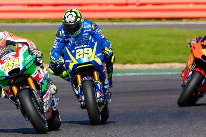 Pebalap Suzuki Ecstar, Andrea Iannone (tengah), berusaha mengejar Aleix Espargaro saat menjalani balapan MotoGP Inggris di Sirkuit Silverstone, Inggris (27/8/2017).