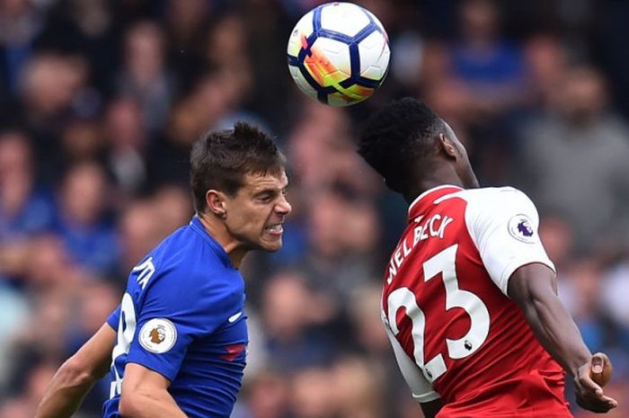 Penyerang Arsenal, Danny Welbeck, berduel udara dengan bek Chelsea, Cesar Azpilicueta, dalam duel Liga Inggris di Stamford Bridge, London, Minggu (17/9/2017).