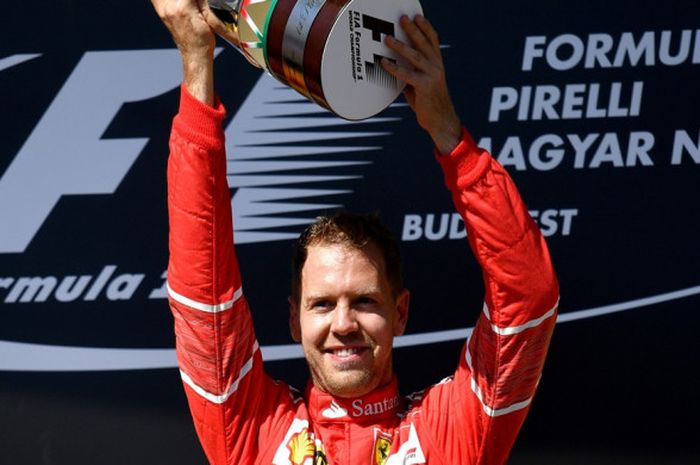 Pebalap Ferrari dari Jerman, Sebastian Vettel, melakukan selebrasi di podium setelah memenangi balapan GP Hungaria di Hungaroring, Budapest, Minggu (30/7/2017).