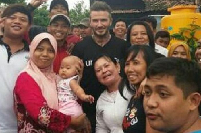  Mantan megabintang Manchester United, David Beckham, diserbu warga yang ingin berfoto saat mengunjungi sebuah sekolah menengah pertama di Pancursari, Tandang, Semarang, Selasa (27/3/2018). 
