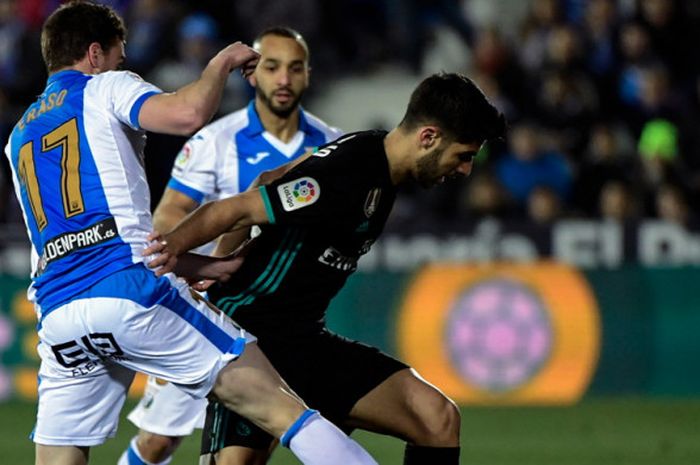 Aksi gelandang Real Madrid, Marco Asensio (kanan), saat mencoba melewati hadapangan pemain Leganes, Javier Eraso (kiri), dalam laga leg 1 perempat final Copa del Rey 2017-2018 di Estadio Municipal Butarque, Leganes, Spanyol, pada Kamis (18/1/2018).