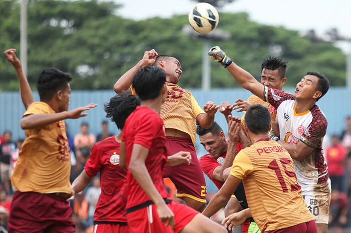 Kiper Persika Karawang (kanan) mengamankan bola dalam kemelut saat timnya bersua Persija pada uji coba di Stadion GMSB, Kuningan, Jakarta Selatan, 30 Desember 2017. 