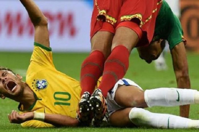 Penyerang Brasil Neymar bereaksi kesakitan setelah tackle yang dilakukan gelandang Kamerun Joel Matip dalam laga Grup A Piala Dunia di Mane Garrincha National Stadium di Brasilia, Selasa (24/6/2014).