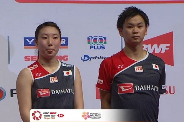 Pasangan ganda campuran Jepang, Yuta Watanabe (kanan) dan Arisa Higshino (kiri), sesaat sebelum menjalani prosesi penyerahan medali usai juara Malaysia Masters 2019, Minggu (20/1/2019).
