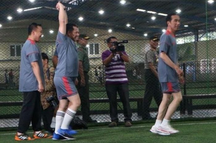 Presiden Joko Widodo (kanan) melakukan pemanasan sebelum bermain futsal dengan wartawan kepresidenan di Time Futsal, Kelapa Gading, Jakarta Utara, Selasa (7/2/2017). 