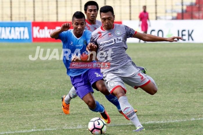 Pemain PSIM Yogyakarta, Engkus Kuswaha (kiri), berupaya merebut bola dari pemain Martapura FC  dalam laga Grup 5 Liga 2 di Stadion Sultan Agung, Bantul, Sabtu (23/4/2017).