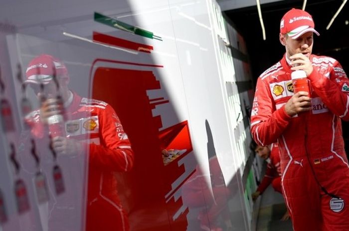 Pebalap Ferrari asal Jerman, Sebastian Vettel, berjalan di sekitar paddock Sochi Autodrom pada sesi latihan kedua GP Rusia, Jumat (28/4/2017).