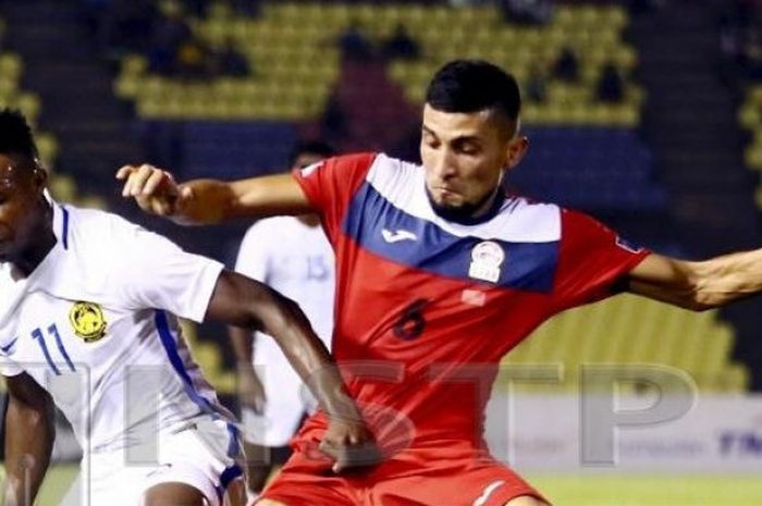 Penyerang naturalisasi timnas Malaysia, Mahamadou Sumareh (kiri) saat berhadapan dengan pemain Kirgistan pada laga FIFA Match Day di Stadion Hang Jebat, Melaka, 16 Oktober 2018. 