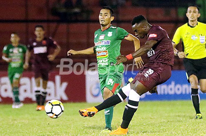 Striker PSM Makassar, Guy Junior, melakukan tendangan dibayangi gelandang PSMS Medan, Legimin Raharj