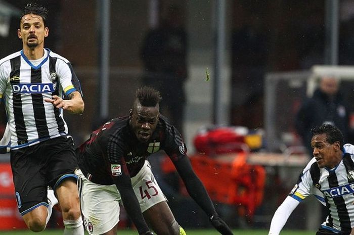 Striker Milan, Mario Balotelli, dijaga ketat oleh dua pemain Udinese pada laga pekan ke-24 Serie A 2015-2016.