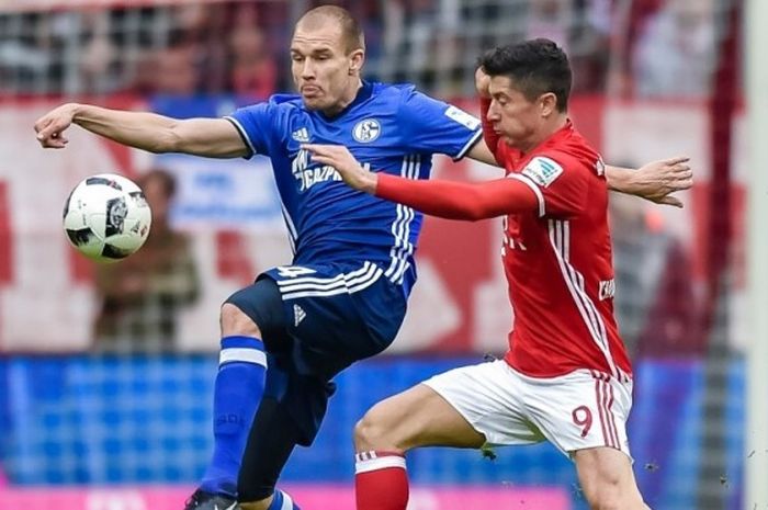 Penyerang Bayern Muenchen, Robert Lewandowski (kanan), berupaya merebut bola dari bek Schalke, Holger Badstuber, dalam partai Bundesliga di Stadion Allianz Arena, Muenchen, 4 Februari 2017.