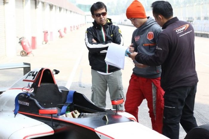 Pebalap Formula 4 (F4) Indonesia, David Sitanala (tengah), berdiskusi dengan manajernya, Stanley Iriawan (kiri), dan perwakilan tim Champ Motosports yang menaungi David pada ajang F4 China.