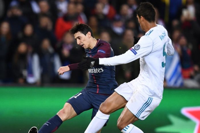 Pemain Paris Saint-Germain, Angel Di Maria (kiri), berduel dengan bek Real Madrid, Raphael Varane, dalam laga leg kedua babak 16 besar Liga Champions di Stadion Parc des Princes, Paris, Prancis, pada 6 Maret 2018.