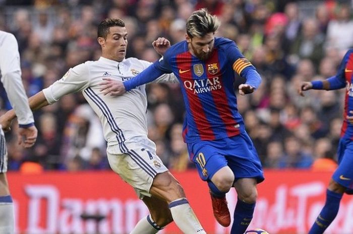 Pemain FC Barcelona, Lionel Messi, sedang dibayang-bayangi oleh pemain Real Madrid, Cristiano Ronaldo, dalam laga La Liga di Stadion Camp Nou, 3 Desember 2016.