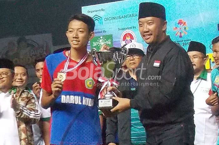 Kapten tim Darul Huda Ponorogo, Fachrul Inzaghi, menerima trofi dari  Menteri Pemuda dan Olahraga, Imam Nahrawi, usai laga final Liga Santri Nusantara 2017 di Stadion Gelora Bandung Lautan Api (GBLA) Kota Bandung, Minggu (29/10/2017).