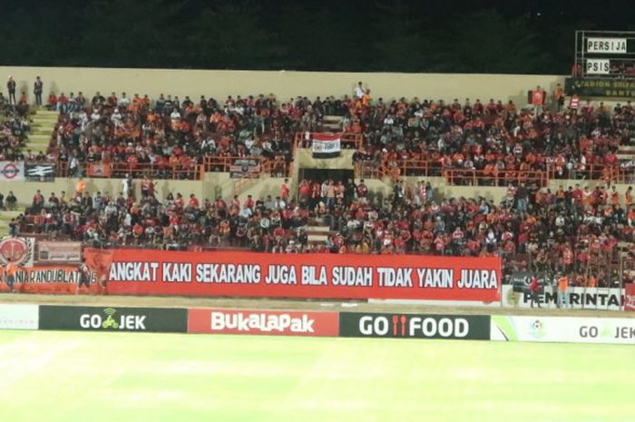 Kelompok suporter Persija Jakarta, The Jakmania, membentangkan spanduk bernada peringatan dalam laga melawan PSIS Semarang pada pekan ke-22 Liga 1 musim 2018 di Stadion Sultan Agung (SSA), Bantul, Selasa (18/9/2018).