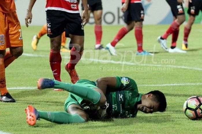 Kiper Madura United Angga Saputra mengerang kesakitan setelah berusaha menangkap bola tembakan pemain Borneo FC di Stadion Ratu Pamelingan, Jumat (13/10/2017)