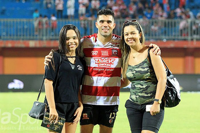 Pemain belakang Madura United, Fabiano Rossa Beltrame, berpose dengan anak dan istrinya usai laga me