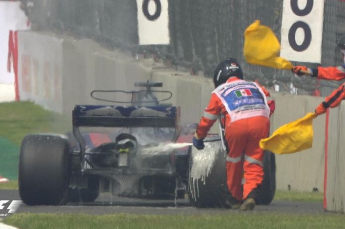 Marshal di Sirkuit Hermanos Rodriguez mencoba memadamkan api di mobil Brendon Hartley (Toro Rosso) saat balapan F1 GP Meksiko, Minggu (29/10/2017). 