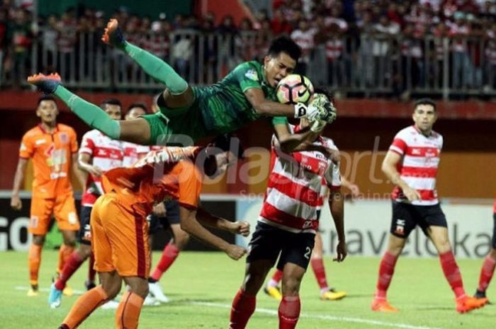 Kiper Madura United Angga Saputra merebut bola tembakan pemain Borneo FC di Stadion Ratu Pamelingan, Jumat (13/10/2017)