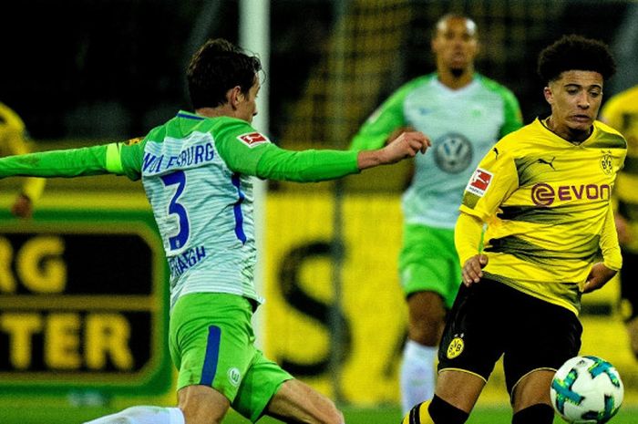 Pemain Borussia Dortmund, Jadon Sancho (kanan), berebut bola dengan bek Wolfsburg, Paul Verhaegh, dalam laga Liga Jerman di Stadion Signal Iduna Park, Dortmund, pada 14 Januari 2018.