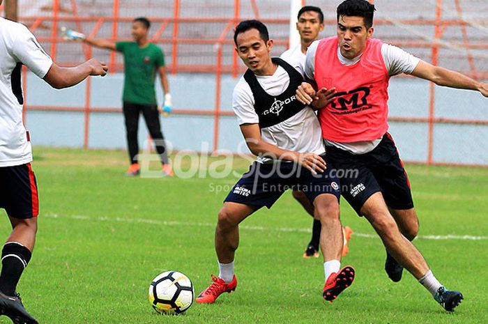  Playmaker Madura United, Slamet Nurcahyo berebut bola dengan rekan setimnya, Fabiano Beltrame, saat berlatih di Stadion Gelora 10 November Surabaya, Jawa Timur, Rabu (02/05/2018) sore. 