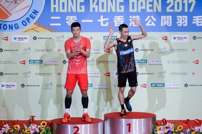 Pebulu tangkis tunggal putra China, Chen Long (kiri) dan Lee Chong Wei (Malaysia) berdiri di podium Hong Kong Terbuka. Lee keluar sebagai juara setelah mengalahkan Chen dengan skor 21-14, 21-19 di Hong Kong Coliseum, Minggu (26/11/2017).
