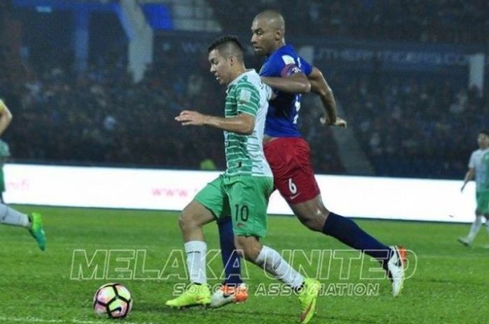 Penyerang Melaka United, Sergio Aguero (hijau) dibayangi bek Johor Darul Takzim, Marcos Antonio pada laga Liga Super Malaysia 2017 di Stadion Larkin, Johor Bahru, Minggu (9/4/2017) malam. 