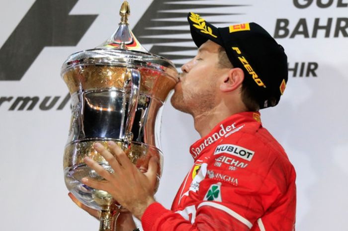 Pebalap Ferrari asal Jerman, Sebastian Vettel  mencium trofi