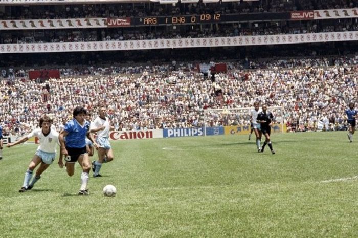   Kapten tim nasional (timnas) Argentina, Diego Maradona, melewati dua pemain Inggris pada pertandingan perempat final Piala Dunia 1986 di Stadion Azteca, Meksiko, 22 Juni 1986.  