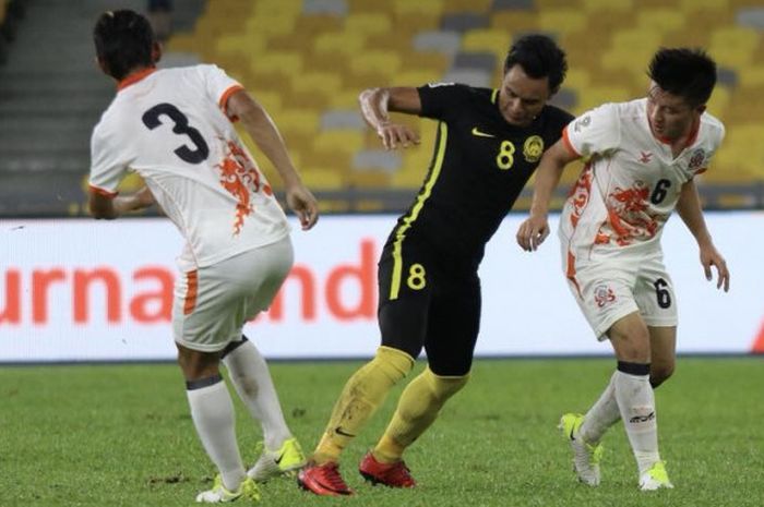 Dua pemain timnas Bhutan mencoba menghentikan laju pilar timnas Malaysia pada uji coba level A di Stadion Nasional Bukit Jalil, Kuala Lumpur pada 1 April 2018. 