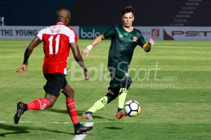 Pemain depan PS Tira, Mariano Berriex, mencoba melewati hadangan striker Madura United, Greg Nwokolo, dalam laga pekan kedua Liga 1 2018 di Stadion Sultan Agung, Bantul, Senin (2/4/2018)