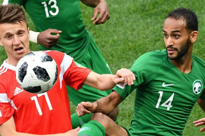 Gelandang Rusia, Aleksandr Golovin, (kiri) dan gelandang Arab Saudi, Abdullah Otayf, berebut untuk mendapatkan bola pada laga pembuka Piala Dunia 2018 antara Rusia dan Arab Saudi di Stadion Luzhniki, Moskow, Kamis (14/6/2018)