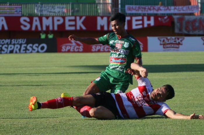  Penyerang PSMS Medan, Suhandi dihadang bek Madura United, Fabiano Beltrame pada laga Liga 1 2018 di Stadion Gelora Ratu Pamelingan, Pamekasan, Jawa Timur, Minggu (8/7/2018). 