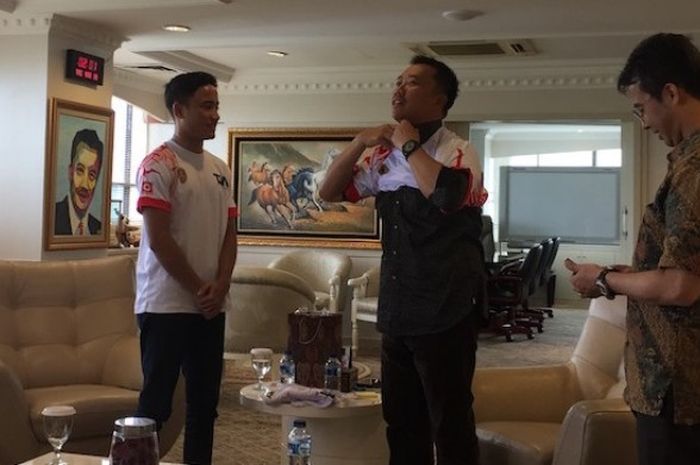 Menteri Pemuda dan Olahraga RI Imam Nahrawi (tengah) memakai kaus yang diberikan oleh pebalap David J Sitanala (kiri) saat bertemu di Wisma Menpora, Jakarta, Jumat (10/3/2017).