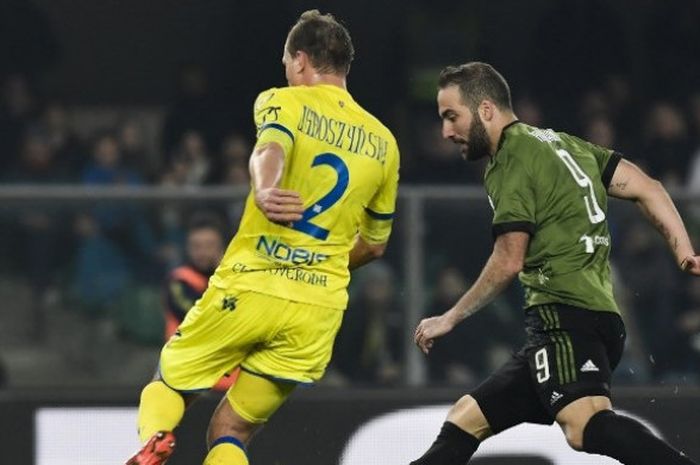 Bek Chievo Verona, Pawel Jaroszynski, (kiri) berhadapan dengan penyerang Juventus, Gonzalo Higuain, dalam laga Liga Italia antara kedua tim di Stadion Marc'Antonio Bentegodi, Minggu (28/1/2017) dini hari WIB.