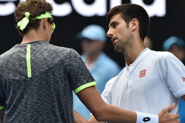 Petenis Serbia, Novak Djokovic (kanan), bersalaman dengan wakil Uzbekistan, Denis Istomin, seusai menelan kekalahan pada babak kedua turnamen Australia Terbuka di Rod Laver Arena, Melbourne Park, Melbourne, Kamis (19/1/2017). Djokovic kalah 6-7(8), 7-5, 6-2, 6-7(5), 4-6.