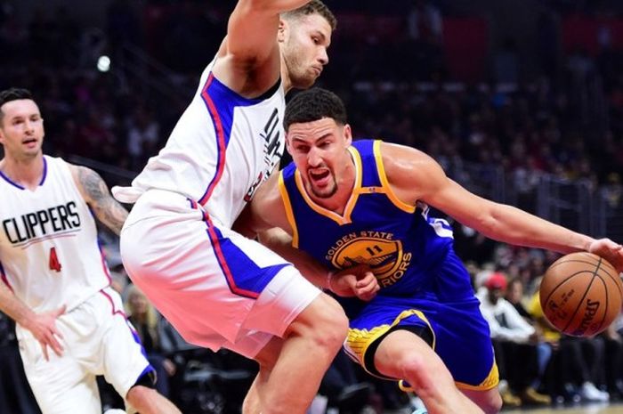 Pebasket Golden State Warriors, Klay Thompson (jersey biru, #11), berupaya melewati hadangan pemain Los Angeles Clippers, Blake Griffin (#32), saat menjalani laga lanjutan musim reguler NBA di Staples Center, Los Angeles, California, Amerika Serikat, Rabu (7/12/2016).