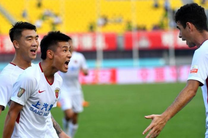 Pemain asal Brasil, Oscar (kanan) disambut rekannya dari Shanghai SIPG seusai mencetak gol ke gawang Beijing Renhe pada laga terbaru Liga Super China 2018 di Stadion Beijing Fengtai, 28 Juli 2018. 