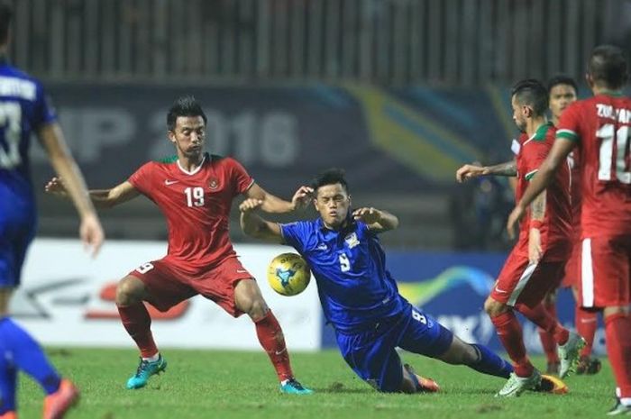   Gelandang Indonesia, Bayu Pradana (19), berduel dengan penyerang Thailand, Sirach Chatthong (9), pada final pertama Piala AFF 2016 di Stadion Pakansari, Kabupaten Bogor, Rabu (14/12/2016) malam.  