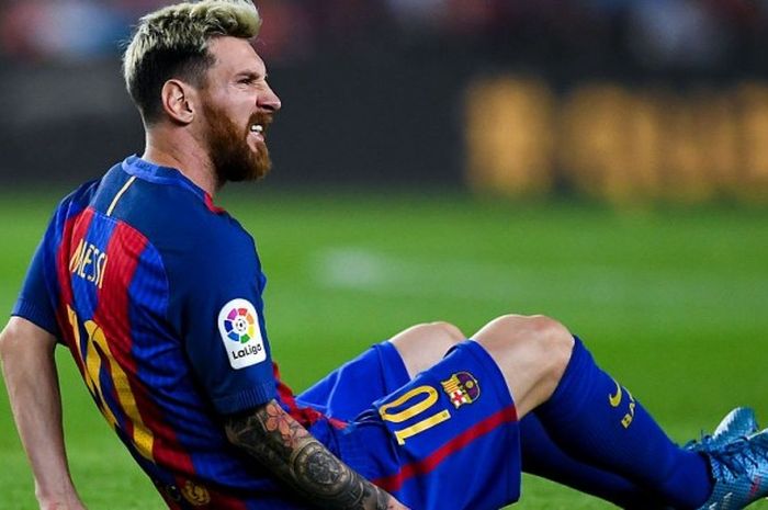 Bintang Barcelona, Lionel Messi, meringis kesakitan sambil terduduk di lapangan akibat cedera dalam laga La Liga kontra Atletico Madrid di Camp Nou, Barcelona, 21 September 2016.