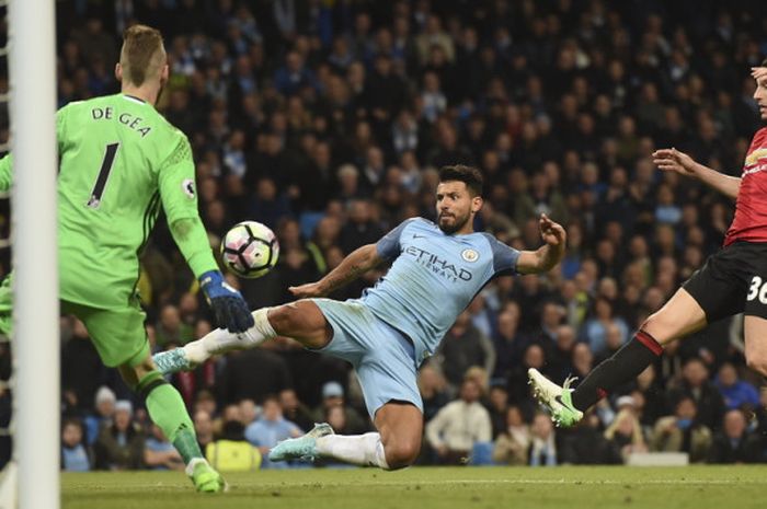 Striker Manchester City, Sergio Aguero (tengah), melepaskan tendangan di antara kawalan dua pemain Manchester United, Matteo Darmian (kanan) dan David De Gea, dalam laga Liga Inggris 2016-2017 di Stadion Etihad, Manchester, Inggris, pada 27 April 2017.