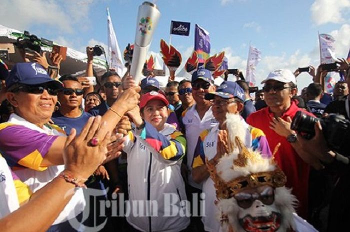 Puan Maharani, Menteri koordinator bidang pembangunan manusia dan kebudayaan tiba mengarak obor abadi Asian Game 2018 di kawasan pantai Kuta, Badung, Senin (23/7/2018). 