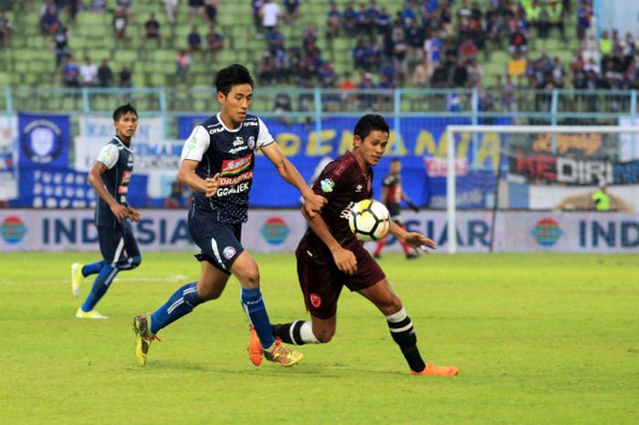 Dua gelandang dari Arema FC, Hanif Sjahbandi dan pilar lini tengah PSM, Rizky Pellu (kanan) berebut bola pada laga pekan kedelapan Liga 1 2018 di Stadion Kanjuruhan, Kabupaten Malang, 13 Mei 2018. 