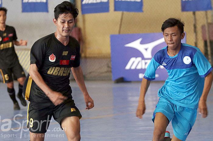 Pemain Universitas Surabaya (hitam) berusaha melewati pemain Universitas Wijaya Putra (biru) pada laga Mizuno University futsal Tournament, Sabtu (25/8/2018) di Surabaya Futsal Center.