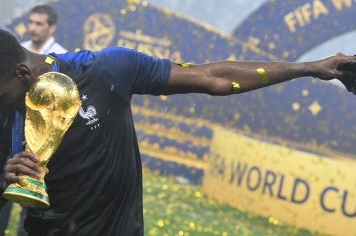 Gaya Paul Pogba saat memegang trofi Piala Dunia 2018 yang dimenanginya bersama timnas Prancis seusai mengalahkan Kroasia pada final yang berlangsung di Stadion Luzhniki pada 15 Juli 2018.