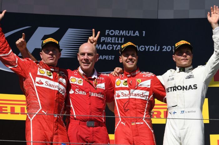 Pebalap Ferrari, Sebastian Vettel dan Kimi Raikkonen (wearpack merah), mengapit team engineer Jock Clear dan berpose bersama pebalap Mercedes, Valtteri Bottas, di podium GP Hungaria. Tim Ferrari sukses finis 1-2 di Hungaroring, Minggu (30/7/2017).