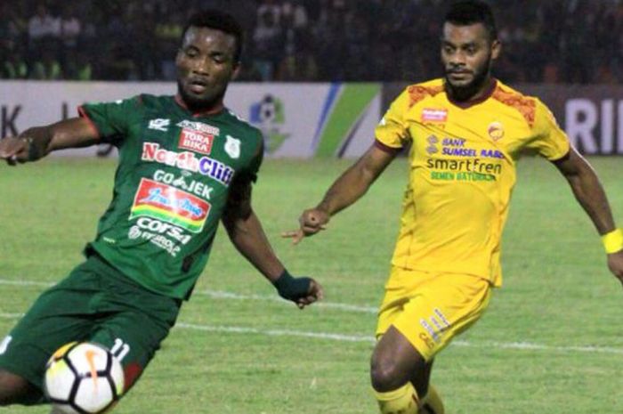  Pemain PSMS Medan, Wilfried Yessoh dan pemain Sriwijaya FC, Marckho Sandy berduel dalam laga pekan ke-9 Liga 1 musim 2018 du Stadion Teladan, Medan, Jumat (18/5/2018). 